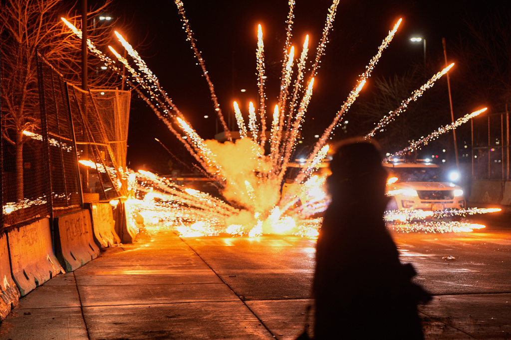 Fireworks are set off by protesters outside the Bishop Henry Whipple Federal Building, Monday, Jan. 12, 2026, in Minneapolis. (AP Photo/Jen Golbeck)
