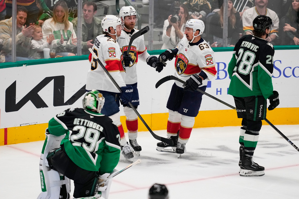 Florida Panthers' Carter Verhaeghe (23), Sam Bennett (9) and Brad Marchand (63) celebrate Bennett's goal as Dallas Stars' Jake Oettinger (29) and Alexander Petrovic (28) look on in the second period of an NHL hockey game in Dallas, Saturday, Dec. 13, 2025. (AP Photo/Tony Gutierrez)