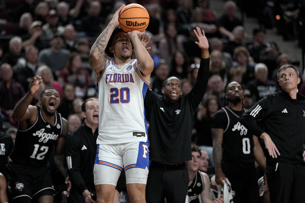 Florida guard Isaiah Brown (20) shoots a 3-point basket in front of the Texas A&M bench during the first half of an NCAA college basketball game Saturday, Feb. 7, 2026, in College Station, Texas. (AP Photo/Sam Craft)