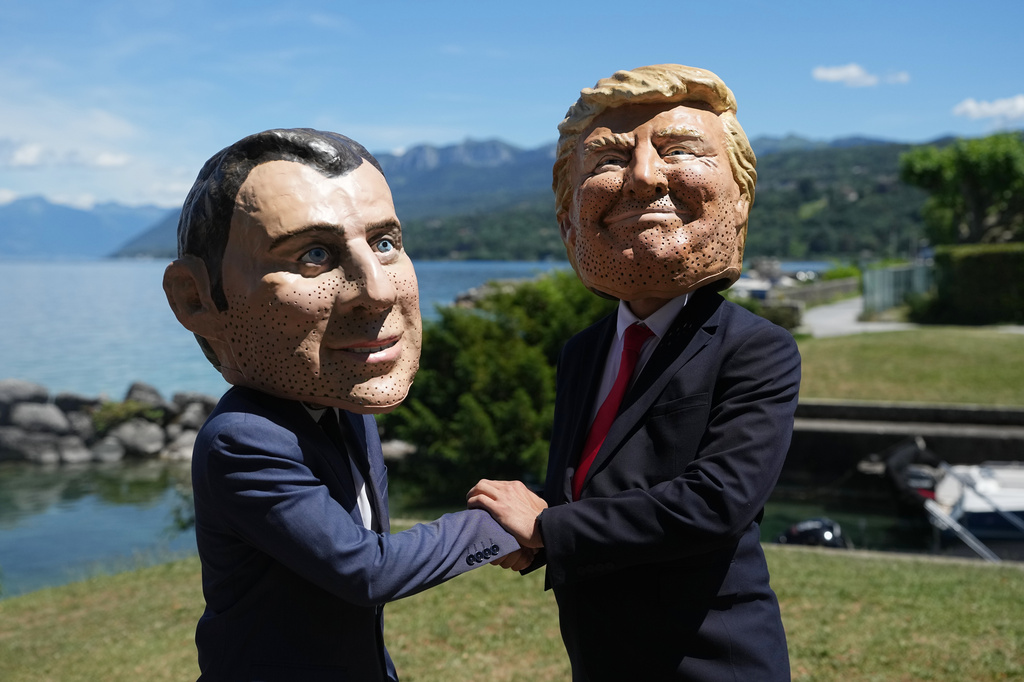 Oxfam's satirical 'big heads' of the G7 leaders depicting French President Emmanuel Macron, left, and U.S. President Donald Trump pose, in Evian-les-Bains, France, Sunday, June 14, 2026, ahead of the G7 summit scheduled to take place in France June 15-17. (AP Photo/Thibault Camus)