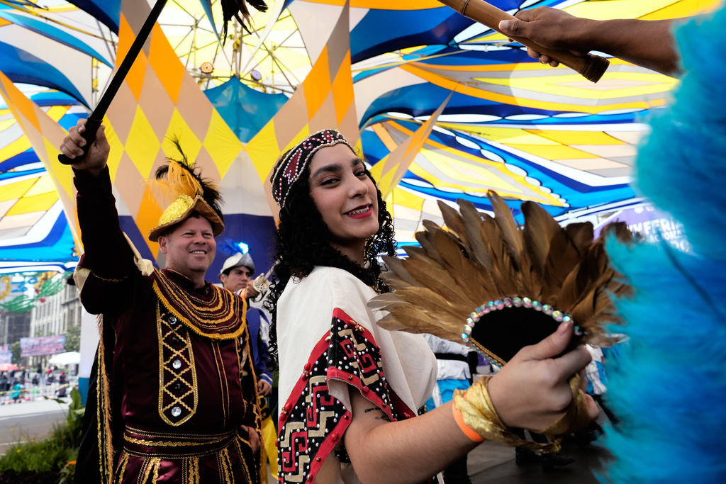 La Malinche, represented by Ximena Isabel Ochoa López, and Hernán Cortez, represented by José Antonio Ochoa Lopez, left, take part in a pre-Hispanic dance in the Zocalo, in Mexico City, Sunday, Oct. 12, 2025. (AP Photo/Marco Ugarte)