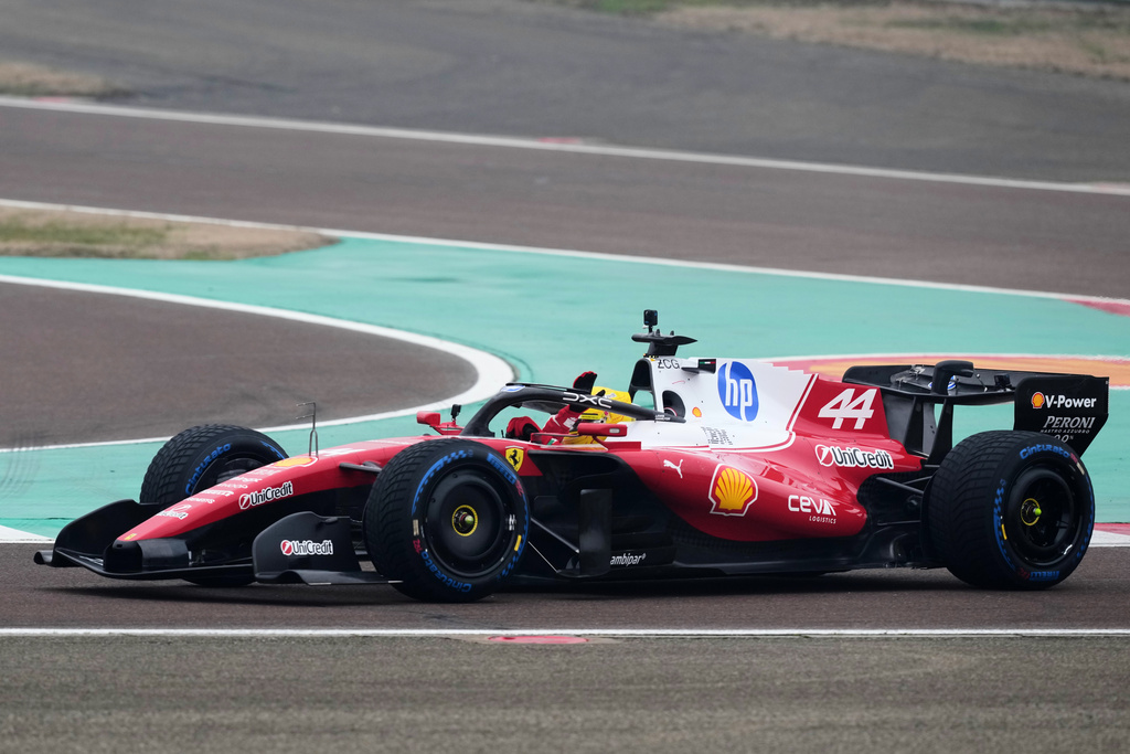 Britain's Lewis Hamilton waves to fans as he steers his Ferrari Formula One SF-26 at the Ferrari private test track, in Fiorano Modenese, Italy, Friday, Jan. 23, 2026. (AP Photo/Antonio Calanni)