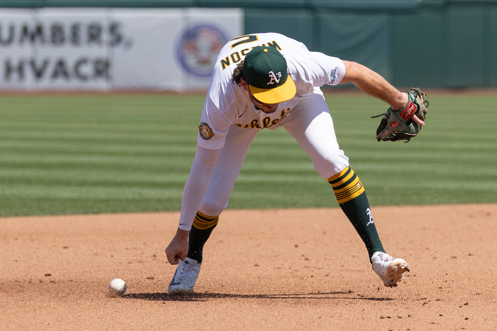 Athletics shortstop Jacob Wilson attempts to field a ball during the fourth inning of a baseball game against the Texas Rangers, Sunday, Aug. 16, 2026, in West Sacramento, Calif. (AP Photo/Sara Nevis)