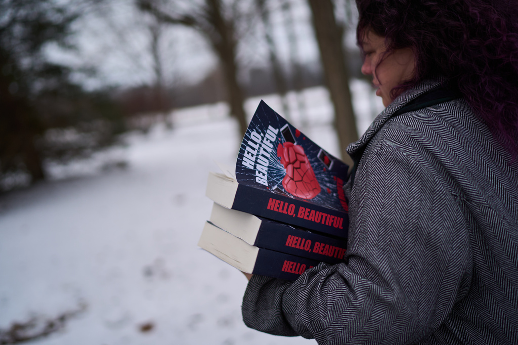 Jean Booth, who was targeted in a romance scam, carries copies of the book she wrote about her experience titled, "Hello Beautiful," which was how her scammer used to greet her, in Westlake, Ohio, Tuesday, Dec. 9, 2025. (AP Photo/David Goldman)