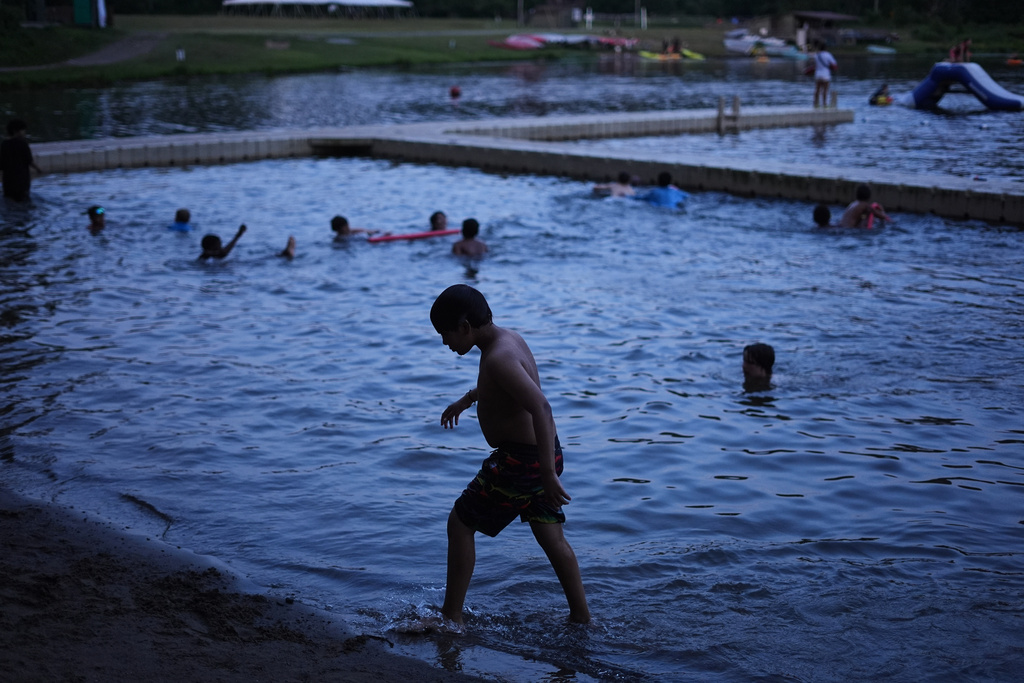 Dylan Aristy Mota, 12, of New York City, who has lupus, walks out of the water doing an evening swim at the Frost Valley YMCA sleepaway camp in Claryville, N.Y., Wednesday, July 30, 2025. The camp partnered with Children's Hospital at Montefiore so kids with autoimmune diseases could attend for the first time. (AP Photo/Matt Rourke)