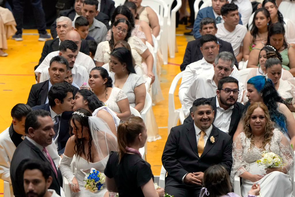 Couples attend a group ceremony organized by the Civil Registry to legally formalize their unions in in Asuncion, Paraguay, Saturday, Oct. 4, 2025. (AP Photo/Jorge Saenz)