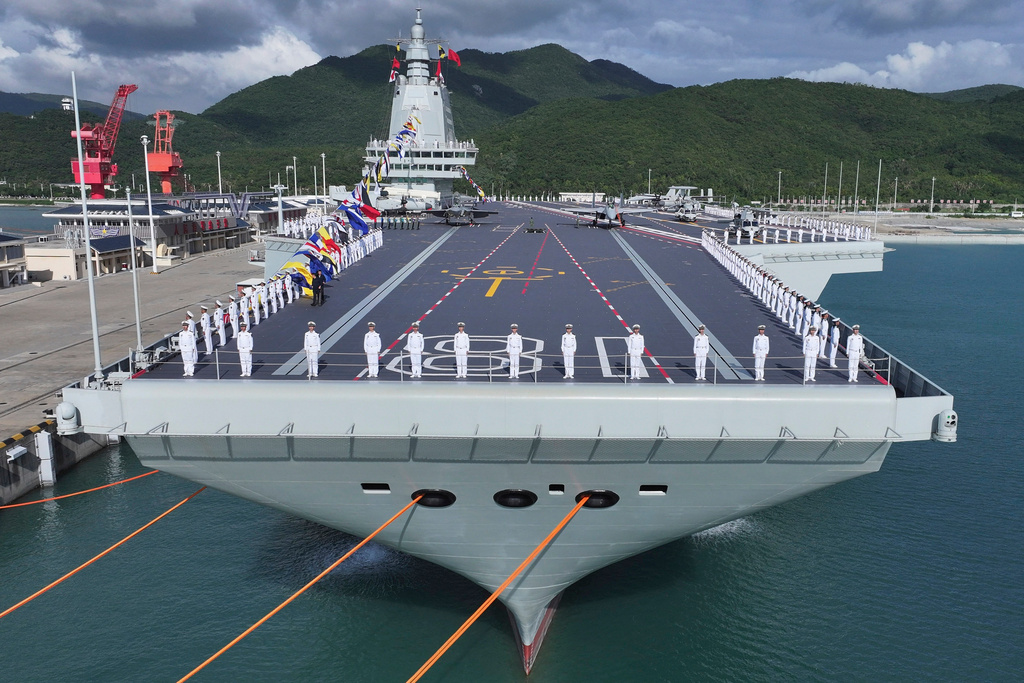 In this photo released by Xinhua News Agency, a commissioning and flag-presenting ceremony is held for the Fujian, China's third aircraft carrier and the first that it has both designed and built itself equipped with electromagnetic catapults, at a naval port in Sanya city in southern China's Hainan Province, on Wednesday, Nov. 5, 2025. (Li Gang/Xinhua via AP)