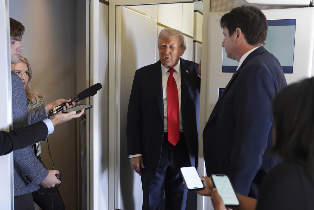 President Donald Trump speaks with journalists on Air Force One en route to Stansted Airport near London, Tuesday, Sept. 16, 2025. (AP Photo/Evan Vucci)