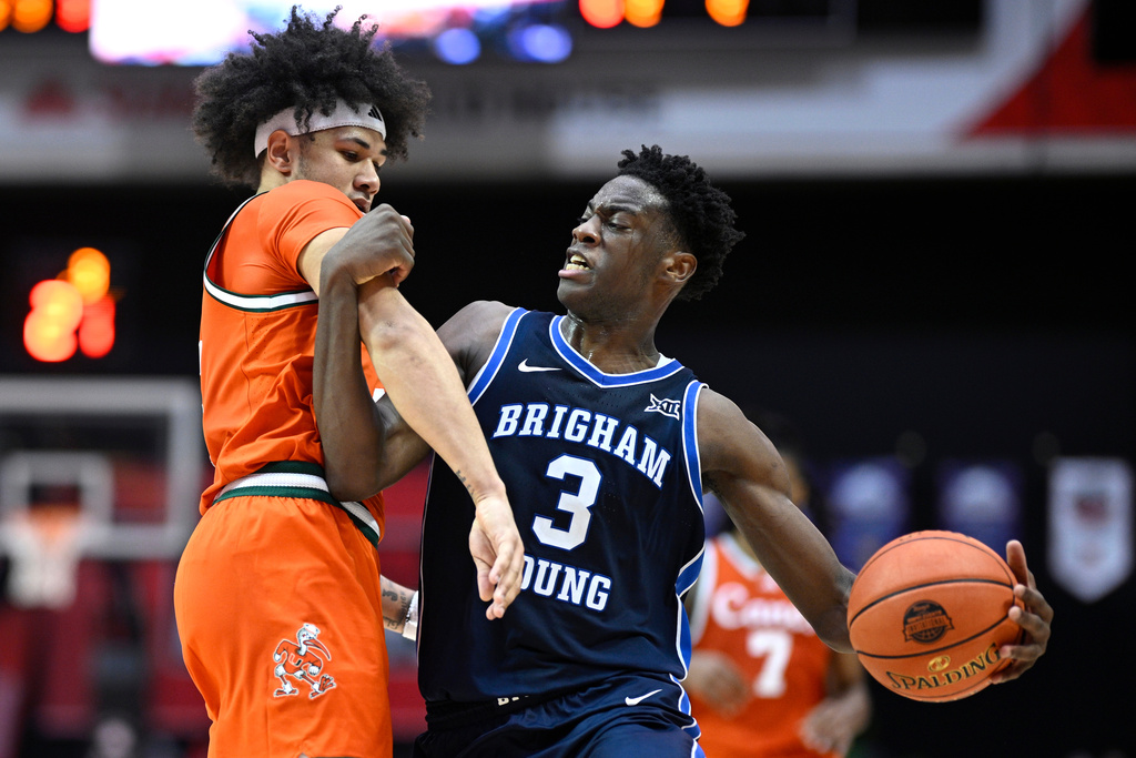 BYU forward AJ Dybantsa (3) is defended by Miami guard Tre Donaldson, left, during the second half of an NCAA college basketball game, Thursday, Nov. 27, 2025, in Kissimmee, Fla. (AP Photo/Phelan M. Ebenhack)