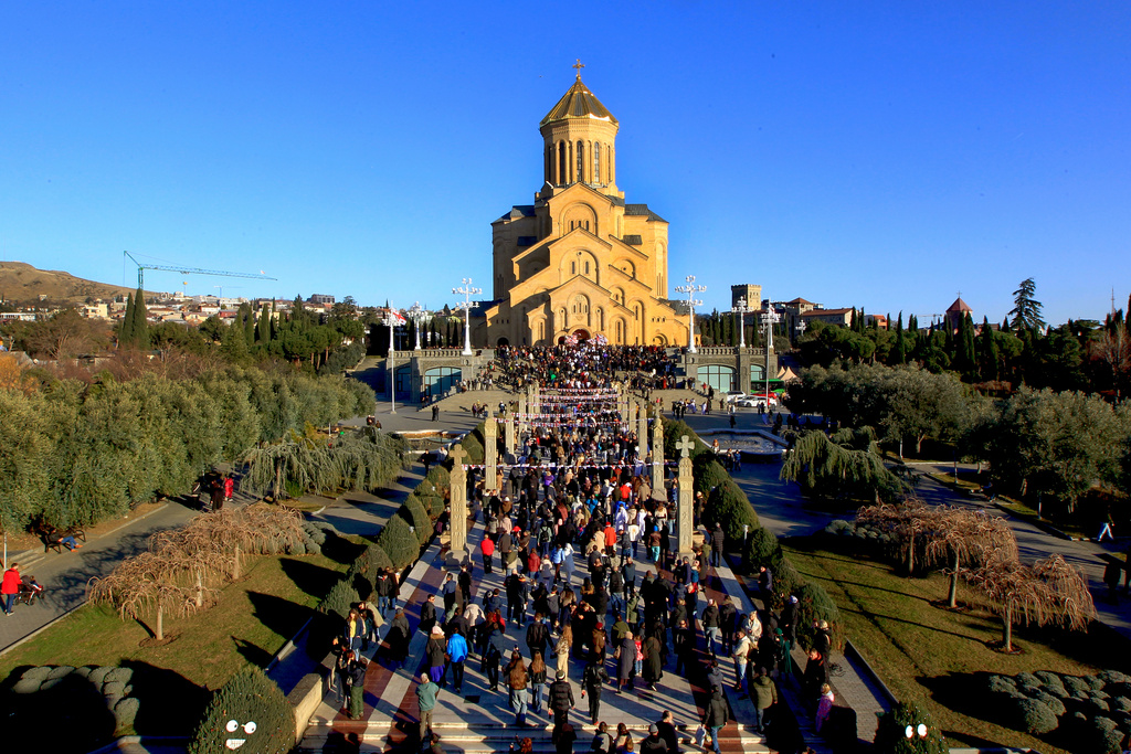 Georgians with national flags take part in a religious procession to the Holy Trinity Cathedral to mark Orthodox Christmas in Tbilisi, Georgia, Wednesday, Jan. 7, 2026. (AP Photo/Shakh Aivazov)