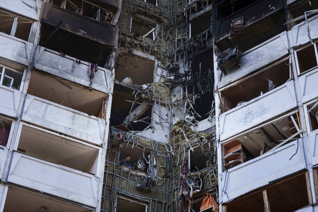 A man is seen among rubble from his apartment damaged by a Russian strike in Kyiv, Ukraine, on Thursday, Aug. 28, 2025. (AP Photo/Evgeniy Maloletka)