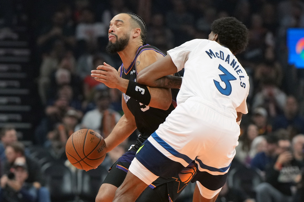Phoenix Suns forward Dillon Brooks, left, drives against Minnesota Timberwolves forward Jaden McDaniels (3) during the first half of an NBA Cup basketball game, Friday, Nov. 21, 2025, in Phoenix. (AP Photo/Rick Scuteri)