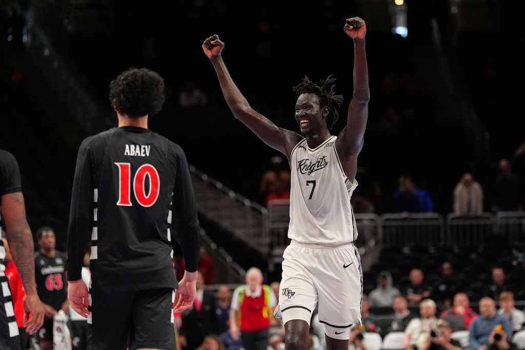 UCF's John Bol (7) celebrates as Cincinnati's Shon Abaev (10) walks past following an NCAA college basketball game in the second round of the Big 12 Conference tournament Wednesday, March 11, 2026, in Kansas City, Mo. (AP Photo/Charlie Riedel)