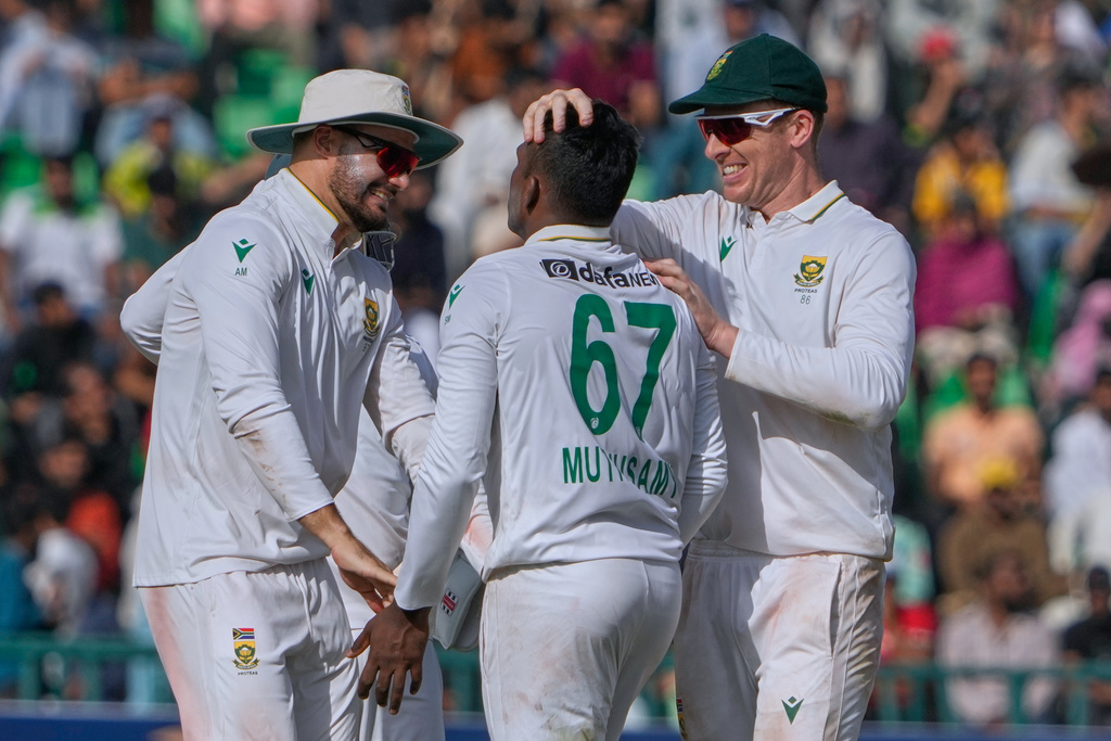 South Africa's Senuran Muthusamy, center, is congratulated by teammates after he taking the wicket of Pakistan's Saud Shakeel during the first day of of first test cricket match between Pakistan and South Africa, in Lahore, Pakistan, Sunday, Oct. 12, 2025. (AP Photo/K.M. Chaudary)