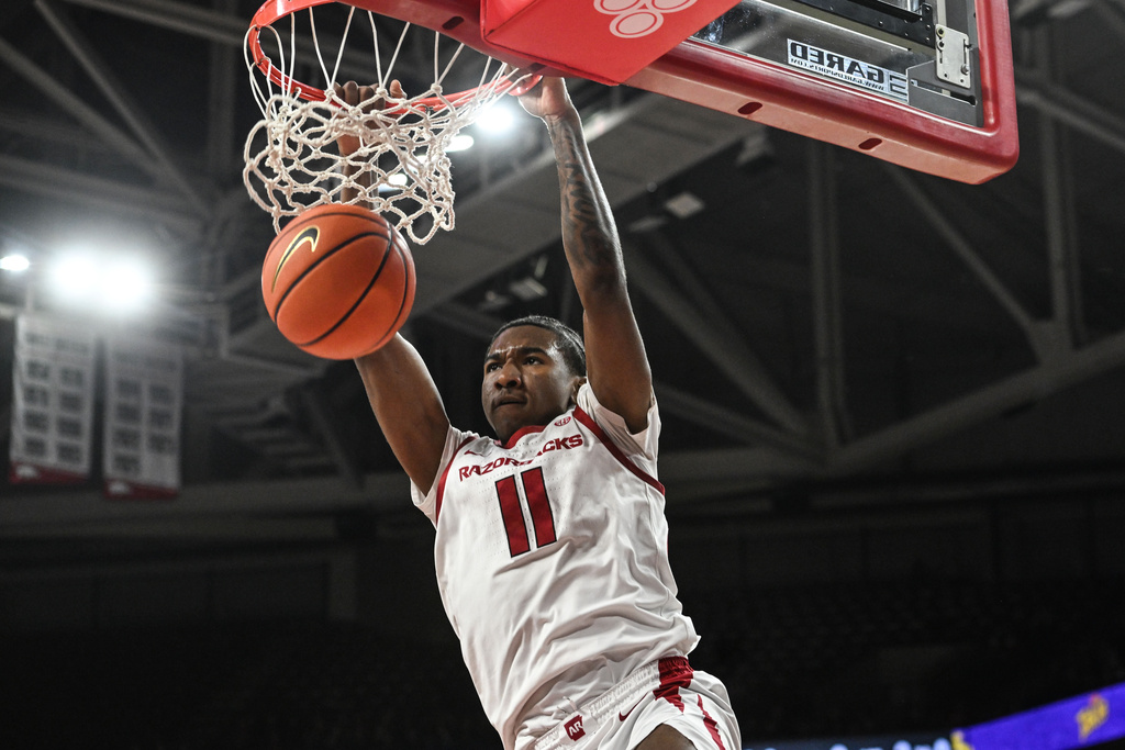 Arkansas guard Karter Knox (11) dunks the ball on a fast break against Queens during the first half of an NCAA college basketball game Tuesday, Dec. 16, 2025, in Fayetteville, Ark. (AP Photo/Michael Woods)