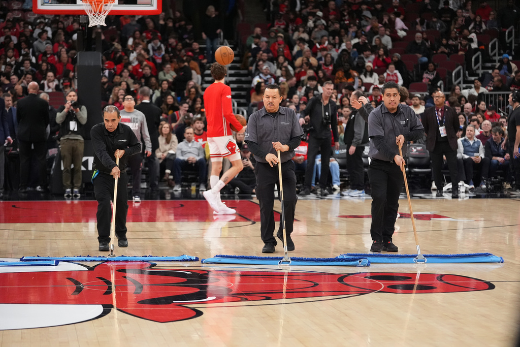 United center employees clean the court during a delay before an NBA basketball game against the Miami Heat in Chicago, Thursday, Jan. 8, 2026. (AP Photo/Nam Y. Huh)