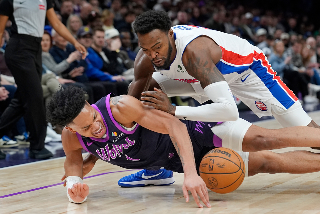 Minnesota Timberwolves guard Terrence Shannon Jr., bottom, loses the ball as Detroit Pistons forward Paul Reed, top, defends in the first quarter of an NBA basketball game Saturday, March 28, 2026, in Minneapolis. (AP Photo/Bruce Kluckhohn)