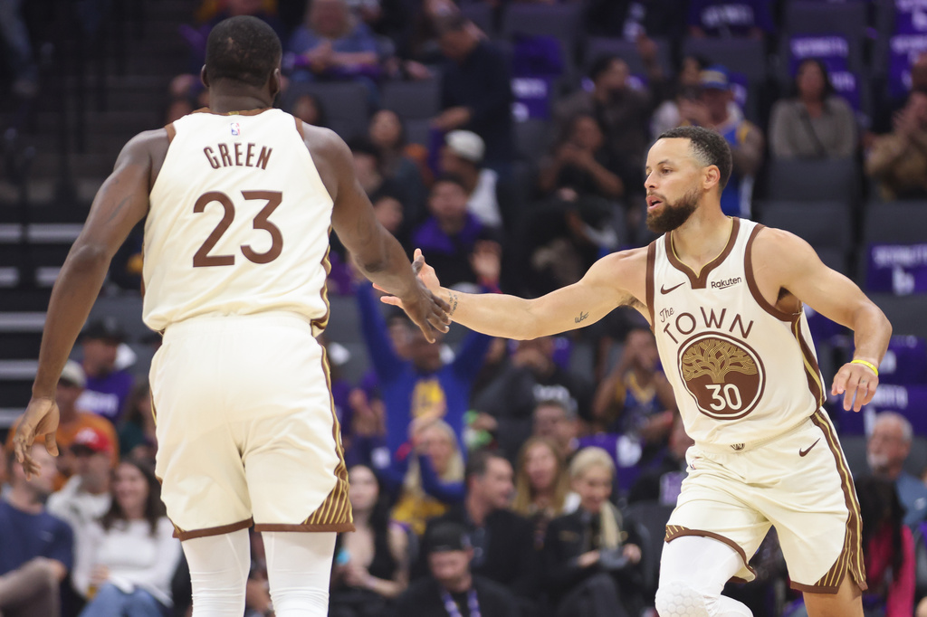 Golden State Warriors guard Stephen Curry (30) high fives Golden State Warriors forward Draymond Green (23) making a three point basket during the first half of an NBA basketball game against the Sacramento Kings, Friday, April 10, 2026, in Sacramento, Calif. (AP Photo/Scott Marshall)