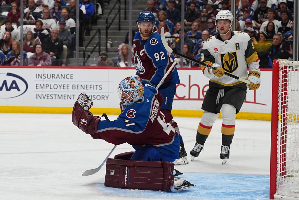 Colorado Avalanche goaltender Scott Wedgewood, front, makes a glove save as left wing Gabriel Landeskog, back left, and Vegas Golden Knights center Jack Eichel looks on during the second period in Game 1 of the Western Conference finals NHL hockey Stanley Cup playoff series Wednesday, May 20, 2026, in Denver. (AP Photo/David Zalubowski)