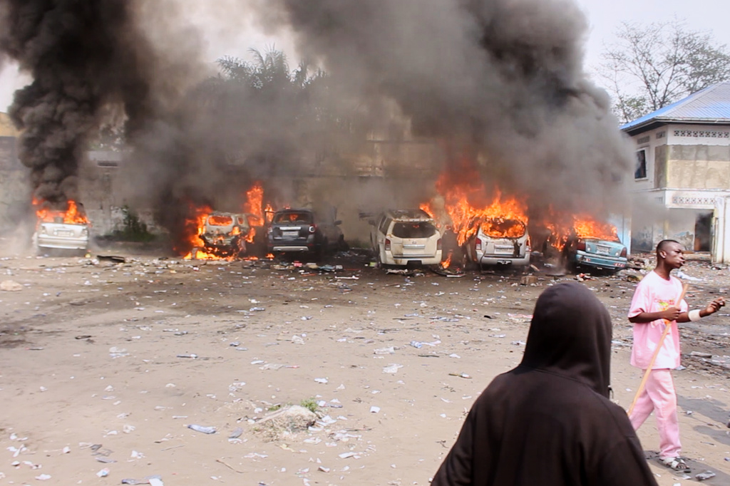Cars burn during a demonstration as Congo's opposition rejects a proposed constitutional change in Kinshasa, Congo, Friday, June 12, 2026. (AP Photo/Ekutshu Yannick)