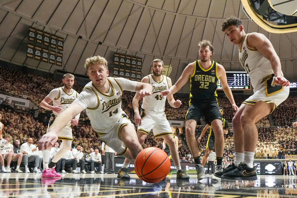 Purdue guard Jack Benter (14) falls out of bounds chasing a loose ball in front of Oregon center Nate Bittle (32) during the first half of an NCAA college basketball game in West Lafayette, Ind., Saturday, Feb. 7, 2026. (AP Photo/AJ Mast)
