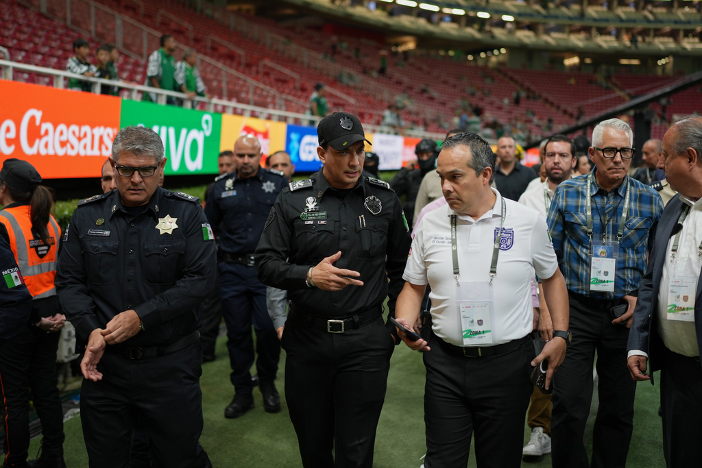 Jalisco State Secretary of Security Juan Pablo Hernández, second from left, chats with Juan Contreras, director of Jalisco state's government security surveillance center, at Akron Stadium prior to a friendly match between Mexico and Ecuador in Guadalajara, Mexico, Tuesday, Oct. 14, 2025. (AP Photo/Eduardo Verdugo)