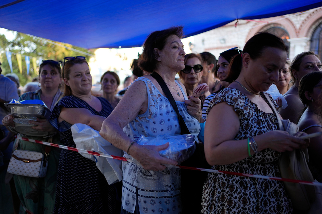 Pilgrims wait in line to have their Fanouropites, orange-flavored cakes, blessed at the Church of St. Fanourios in Athens, Wednesday, Aug. 26, 2026. (AP Photo/Thanassis Stavrakis)