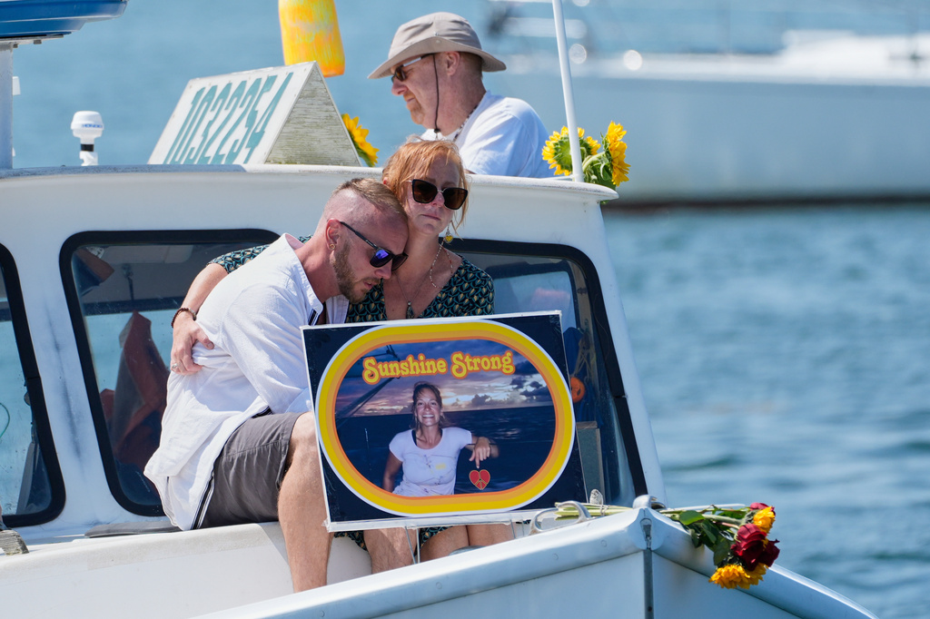 FILE - Acquaintances of Sunshine Stewart sit on the bow of a lobster boat during a memorial service for the slain paddleboarder, Sunday, Aug. 10, 2025, off the coast of St. George, Maine. (AP Photo/Robert F. Bukaty, File)