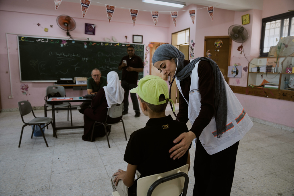 Palestinian patients receive treatment from medical staff with Physicians for Human Rights Israel (PHRI) at a mobile health clinic in the West Bank town of Iktaba, Tuesday, Aug. 4, 2026. (AP Photo/Majdi Mohammed)