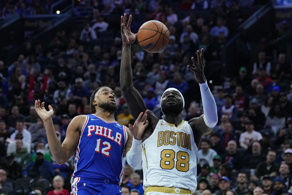 Boston Celtics' Neemias Queta (88) wins the rebound over Philadelphia 76ers' Trendon Watford during the first half of an NBA basketball game Tuesday, Nov. 11, 2025, in Philadelphia. (AP Photo/Matt Rourke)
