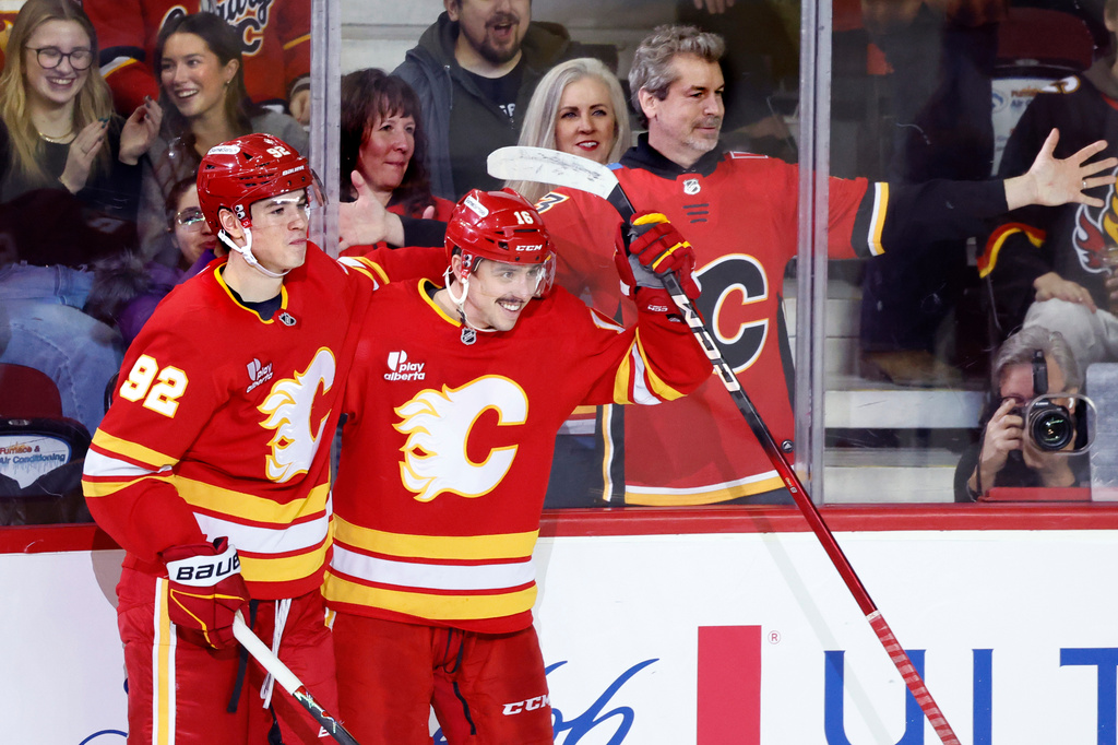 Calgary Flames C Morgan Frost, right, celebrates with RW Matvei Gridin and fans his goal against the Vancouver Canucks during second period NHL hockey action in Calgary, Alberta, Saturday, March 28, 2026. (Larry MacDougal/The Canadian Press via AP)