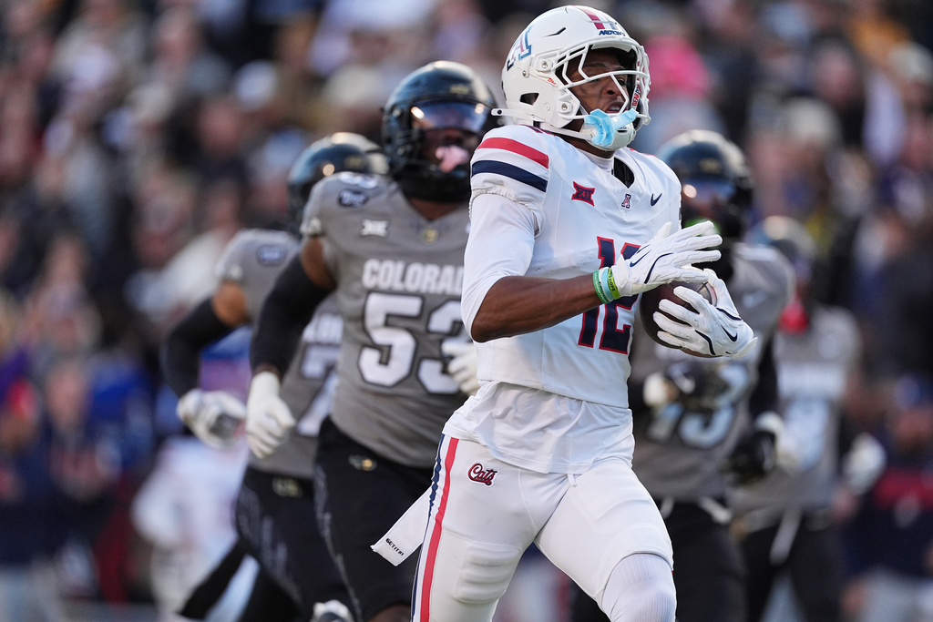 Arizona wide receiver Tre Spivey runs for a touchdown after catching a pass as Colorado defensive end Arden Walker pursues in the first half of an NCAA college football game Saturday, Nov. 1, 2025, in Boulder, Colo. (AP Photo/David Zalubowski)