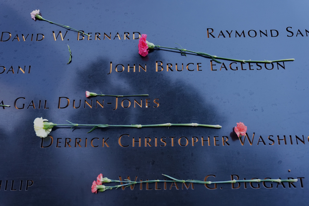 Flowers lay on names inscribed at the 9/11 Memorial before the start of a ceremony commemorating the 24th anniversary of the Sept. 11, 2001, attacks, Thursday, Sept. 11, 2025, in New York. (AP Photo/Seth Wenig)
