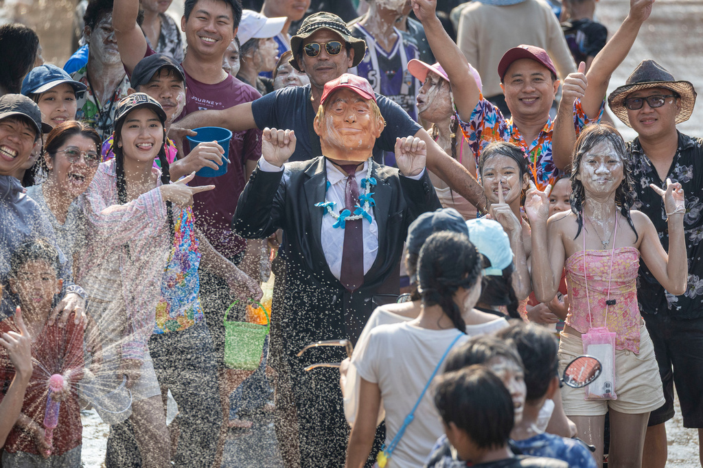 A participant wears a mask of U.S. President Donald Trump during the Songkran water festival to celebrate the Thai New Year in Prachinburi province, Thailand, Monday, April 13, 2026. (AP Photo/Wason Wanichakorn)