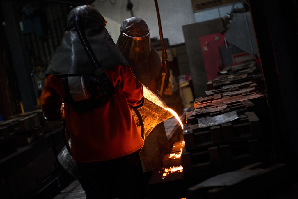 Furnace workers pour molten metal as part of the process to create BAFTA masks at FSE Foundry in Braintree, England on Tuesday, Feb. 10, 2026. (Scott A Garfitt/Invision/AP)