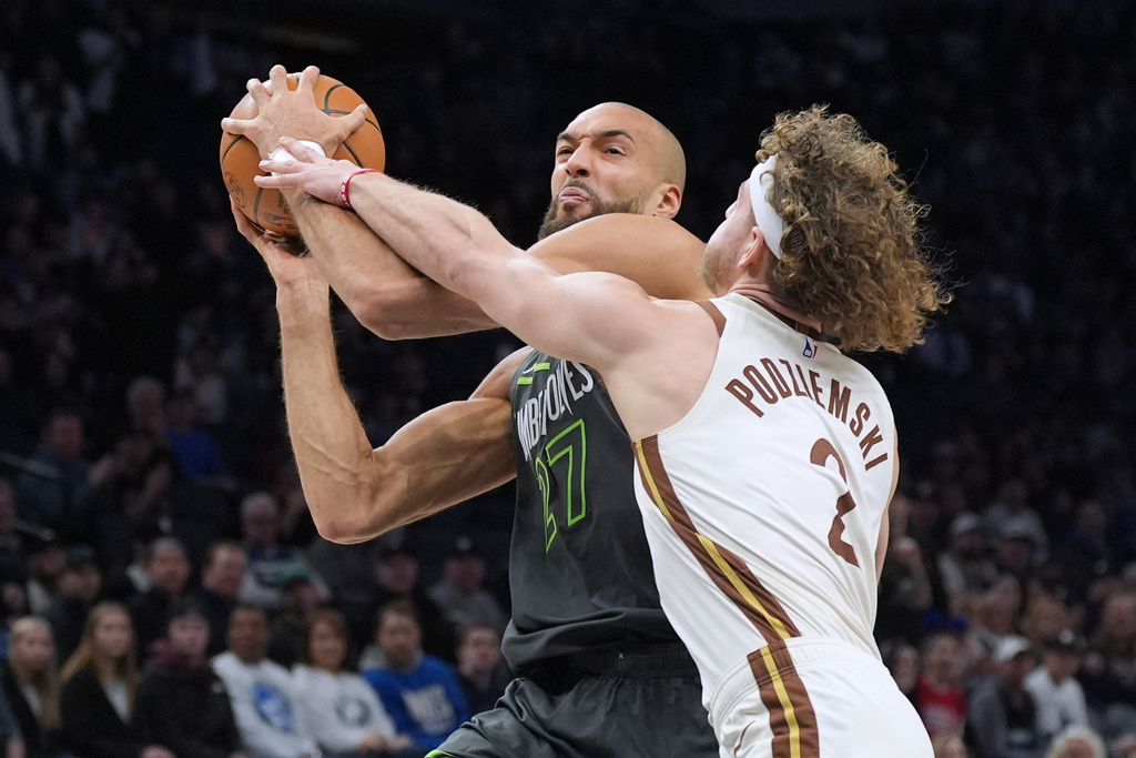 Minnesota Timberwolves center Rudy Gobert, left, is fouled by Golden State Warriors guard Brandin Podziemski (2) during the first half of an NBA basketball game, Monday, Jan. 26, 2026, in Minneapolis. (AP Photo/Abbie Parr)