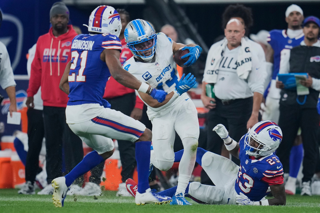 Detroit Lions wide receiver Amon-Ra St. Brown (14) runs after a catch as Buffalo Bills cornerback Davison Igbinosun (21) defends during the second half of an NFL football game in Orchard Park, N.Y., Thursday, Sept. 17, 2026. (AP Photo/Sue Ogrocki)