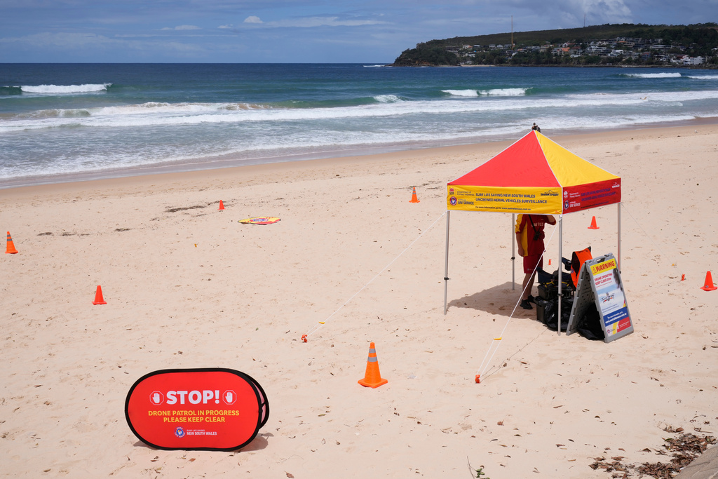 A man is stationed at North Steyne Beach in Sydney as he uses a drone to scan the water, Tuesday, Jan. 20, 2026, after a series of shark attacks. (AP Photo/Rick Rycroft)