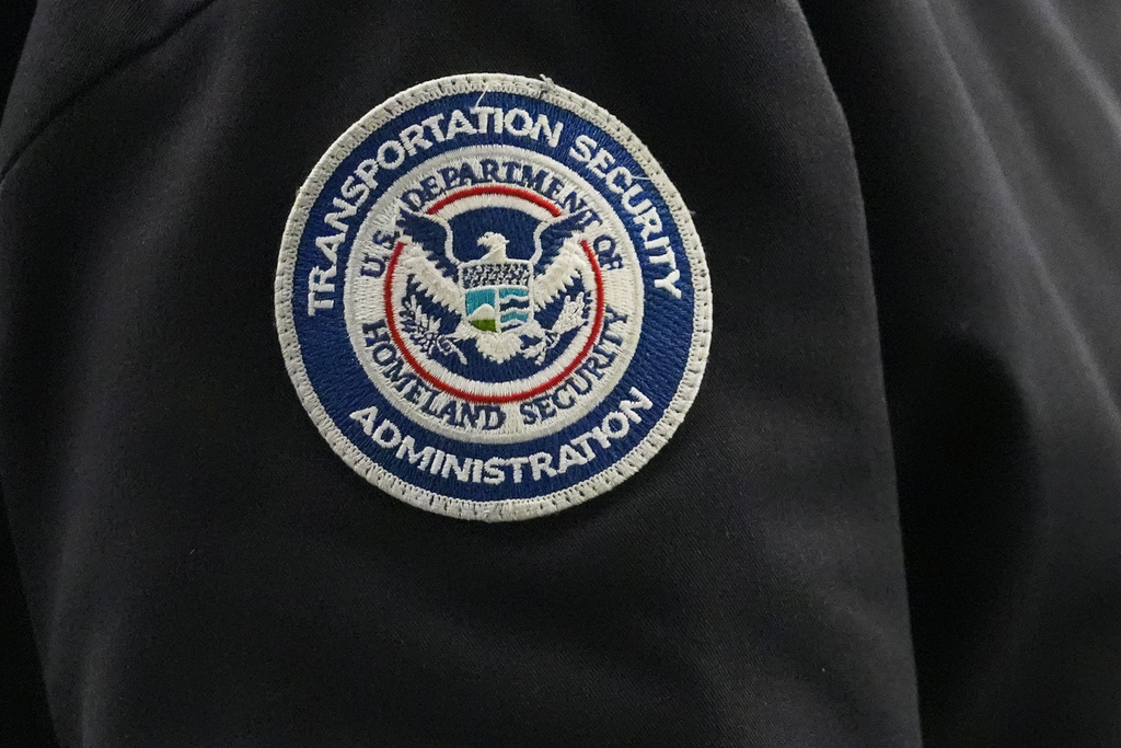 FILE - A TSA agent wears a Transportation Security Administration badge while checking identification at O'Hare International Airport in Chicago,, Nov. 12, 2025. (AP Photo/Nam Y. Huh, File)