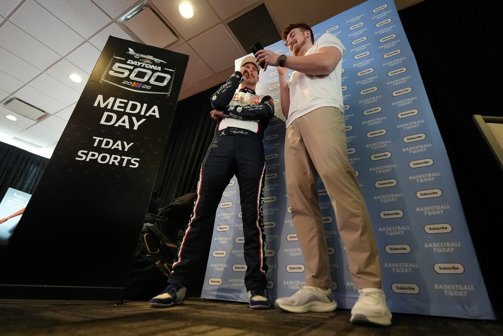 Denny Hamlin speaks with Justin Leusner about basketball trivia for his Basketball Today YouTube channel during a NASCAR Daytona 500 media day, Wednesday, Feb. 11, 2026, in Daytona, Fla. (AP Photo/Mike Stewart)