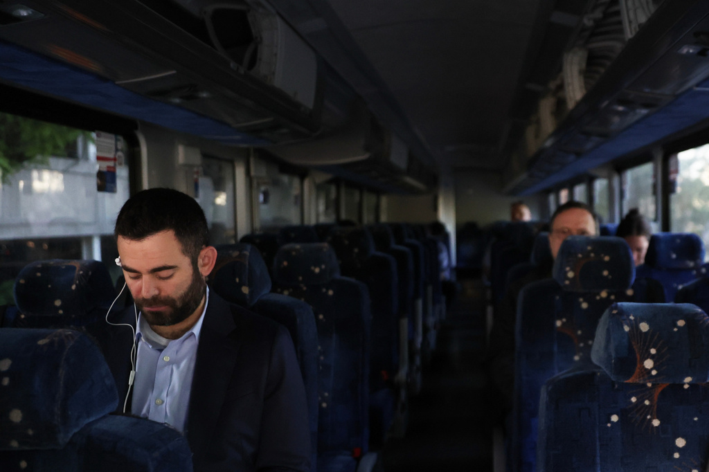 Commuters sit on a shuttle bus as Long Island Rail Road workers strike, Monday, May 18, 2026, in Mineola, N.Y. (AP Photo/Heather Khalifa)