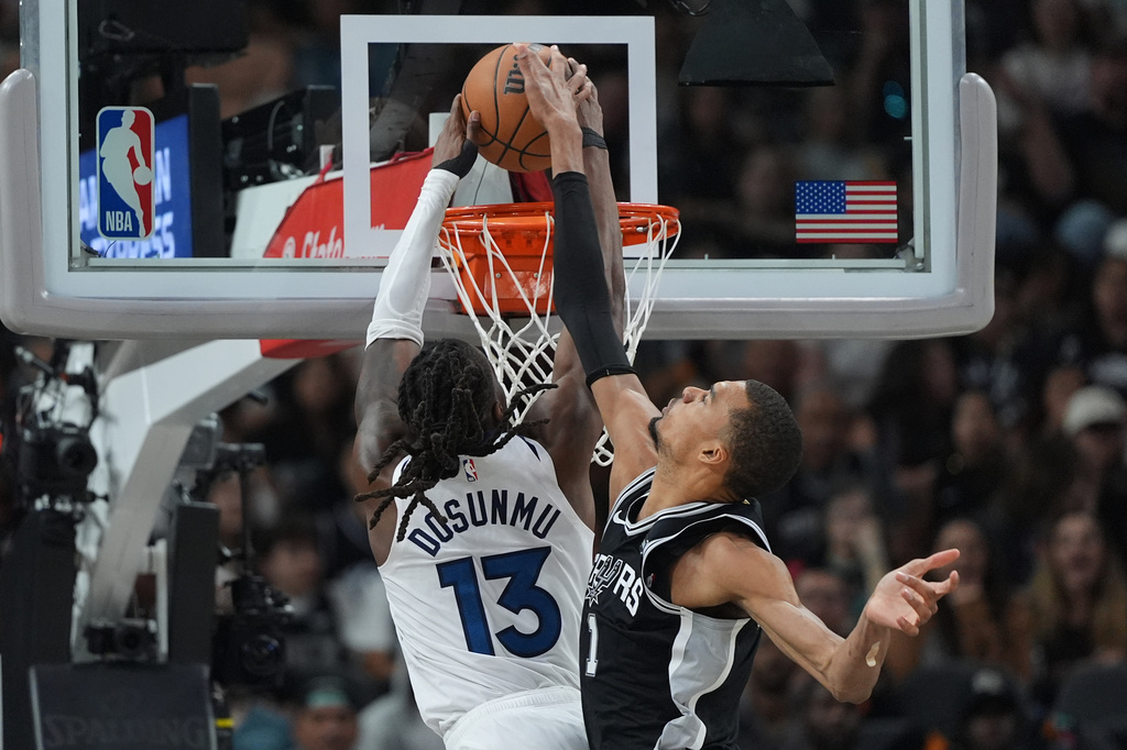 Minnesota Timberwolves guard Ayo Dosunmu (13) scores against San Antonio Spurs forward Victor Wembanyama (1) during the first half of Game 5 of an NBA basketball second-round playoffs series in Minneapolis, Tuesday, May 12, 2026. (AP Photo/Eric Gay)