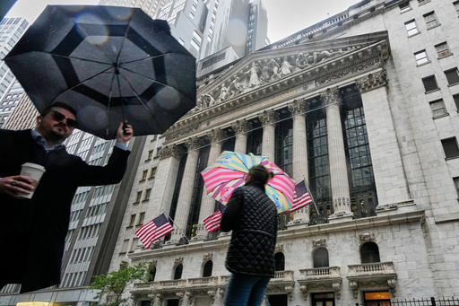 People with umbrellas pass the New York Stock Exchange, Monday, Oct. 13, 2025. (AP Photo/Richard Drew) People with umbrellas pass the New York Stock Exchange, Monday, Oct. 13, 2025. (AP Photo/Richard Drew)