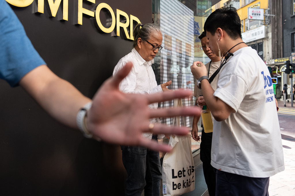 Police officers stop and search artist Sanmu Chen in the Causeway Bay area on the eve of the 37th anniversary of China's Tiananmen Square crackdown in Hong Kong, Wednesday, June 3, 2026. (AP Photo/Chan Long Hei)