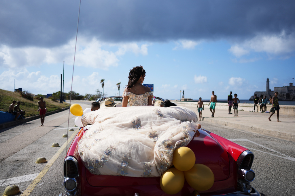 FILE - A quinceanera rides in a vintage car marking her 15th birthday celebration in Havana, Cuba, March 28, 2026. (AP Photo/Ramon Espinosa, File)