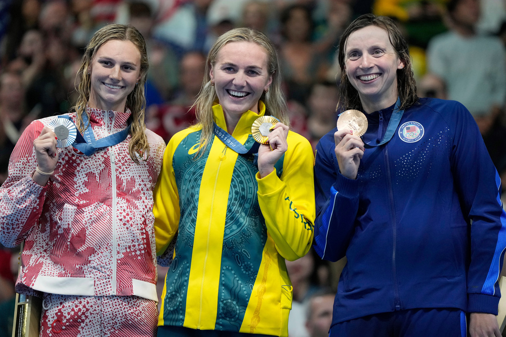 FILE - Gold medalist Ariarne Titmus, of Australia, centre, stands with silver medalist, Summer McIntosh, of Canada, left, and bronze medalist Katie Ledecky, of the United States, on the podium after winning the women's 400-meters freestyle final at the 2024 Summer Olympics, Saturday, July 27, 2024, in Nanterre, France.(AP Photo/Matthias Schrader,FILE)