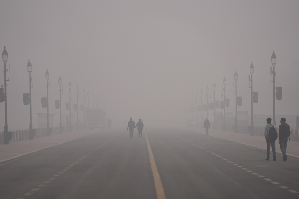People walk in a smog-covered morning in New Delhi, India, Monday, Dec. 15, 2025. (AP Photo/Piyush Nagpal)