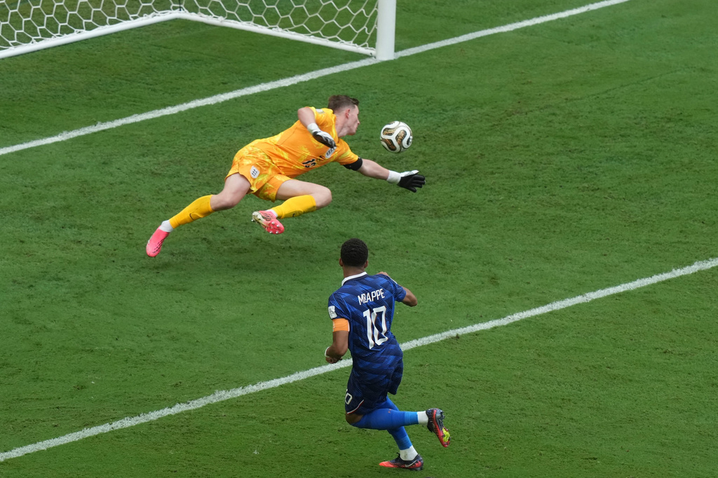 France's Kylian Mbappe (10) scores their first goal past England goalkeeper Dean Henderson (13) during the World Cup third-place playoff soccer match between France and England in Miami Gardens, Fla., Saturday, July 18, 2026. (AP Photo/Marta Lavandier)