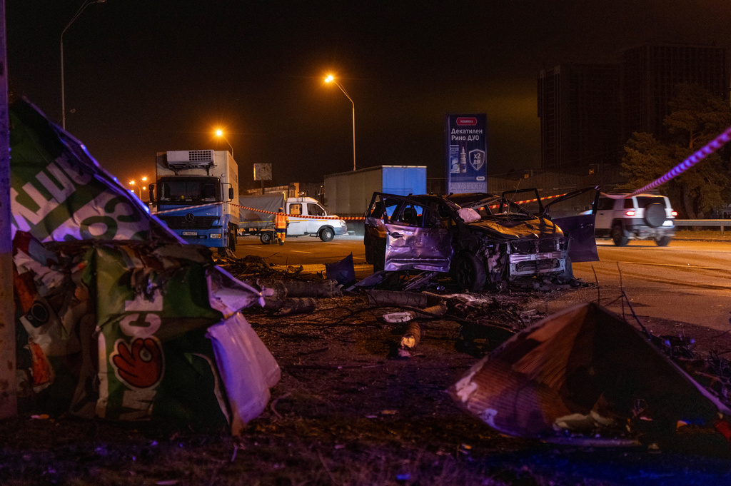 Emergency workers clear debris and damaged road infrastructure near a destroyed car following a Russian overnight strike in Kyiv, Ukraine, Tuesday, Oct. 27, 2026. (AP Photo/Dan Bashakov)