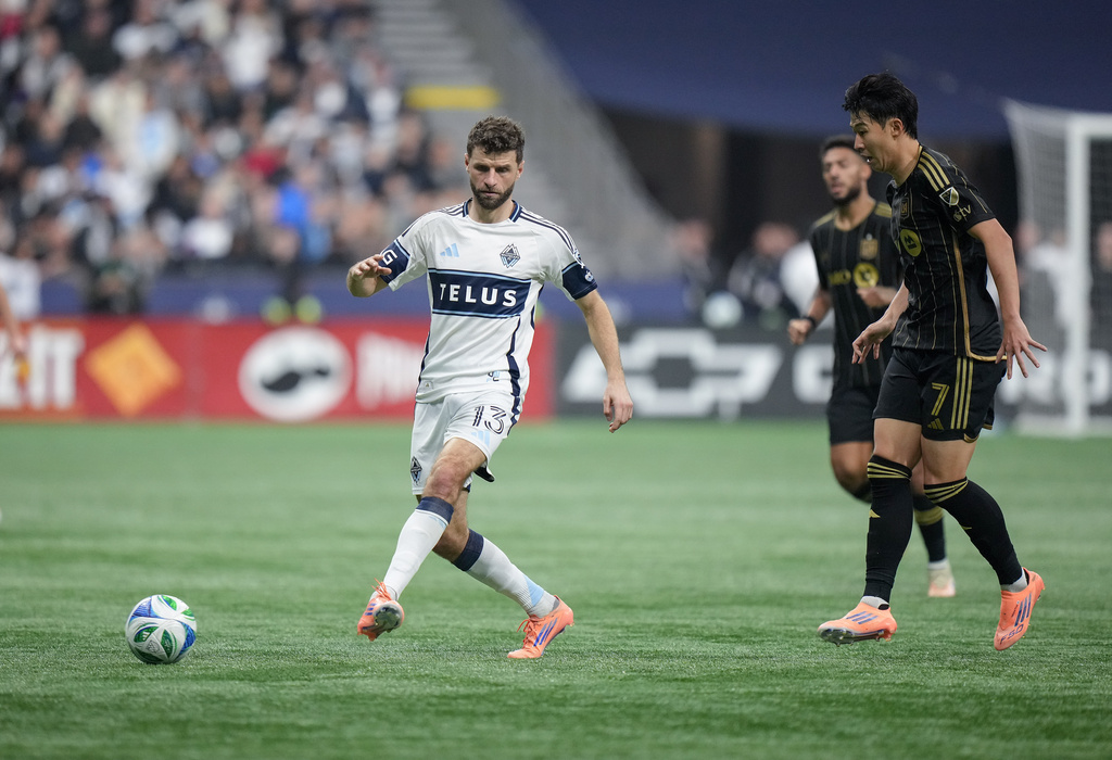 Vancouver Whitecaps' Thomas Muller (13) passes the ball in front of Los Angeles FC's Son Heung-min (7) during the second half of the MLS Western Conference semifinal playoff soccer match, in Vancouver, British Columbia, Saturday, Nov. 22, 2025. (Darryl Dyck/The Canadian Press via AP)